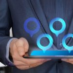 Man holding tablet with location tags - learn what it takes to organize a nationwide relocation.