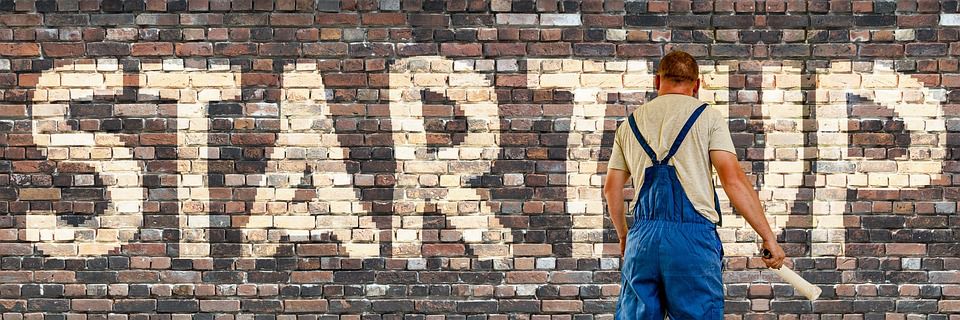 STARTUP painted on a large brick wall.