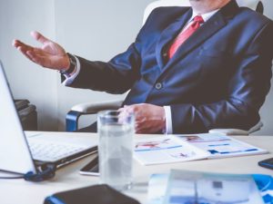 Man in a suit, sitting in office - waiting for customers to call.