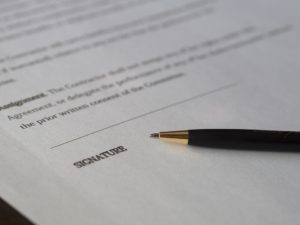 Signature field on a contract with a pen next to it.
