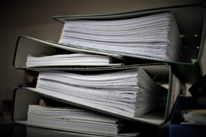 Business paperwork and files on a pile.