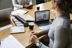 Women in an office, laptop with Business Plan on the table - expanding your business can start.