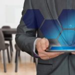 Businessman holding a laptop with revealing business growth strategies.