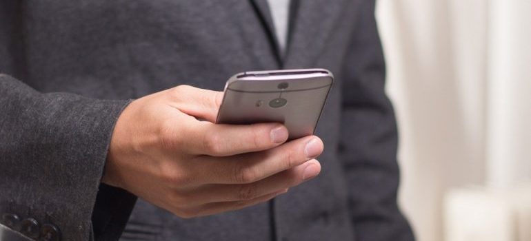 A man checking messages on his smartphone, whilst using one of the top social media tools.