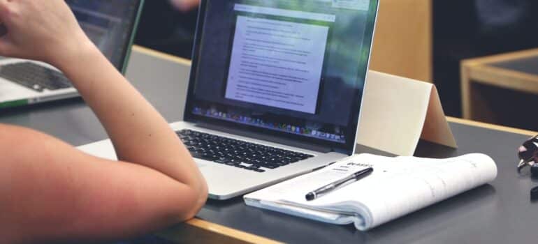 A person writing content on a laptop.