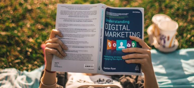 Person holding a book on understanding digital marketing and ways to improve your email marketing strategy.