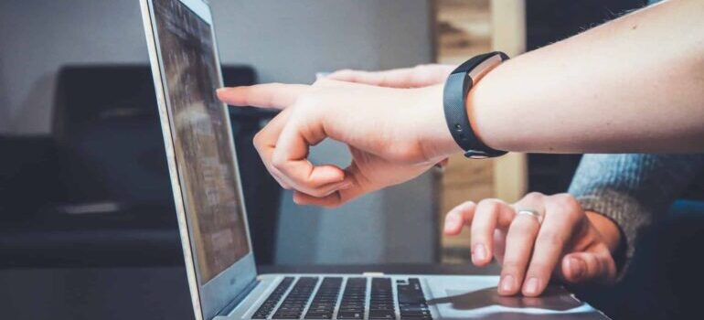 People pointing to anchor text optimization tools on a laptop screen.