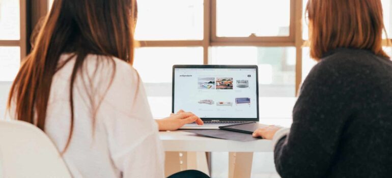Two people are looking through a well-designed movers website.