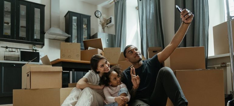 Family doing a self-recording surrounded by moving boxes.
