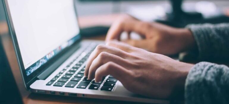 A public relations professional typing a press release on their laptop.