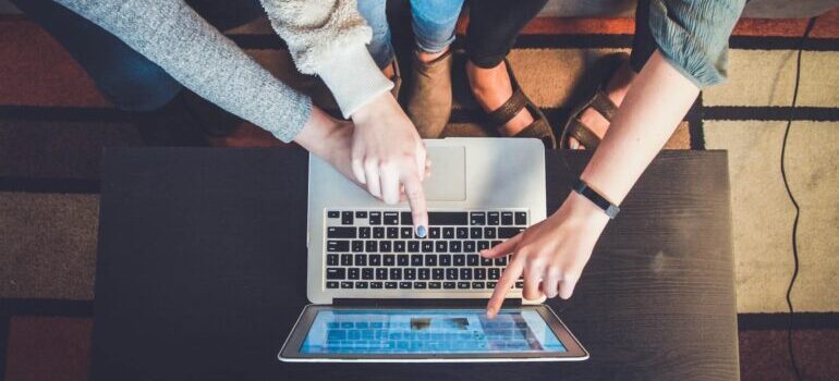 People pointing to a laptop screen.