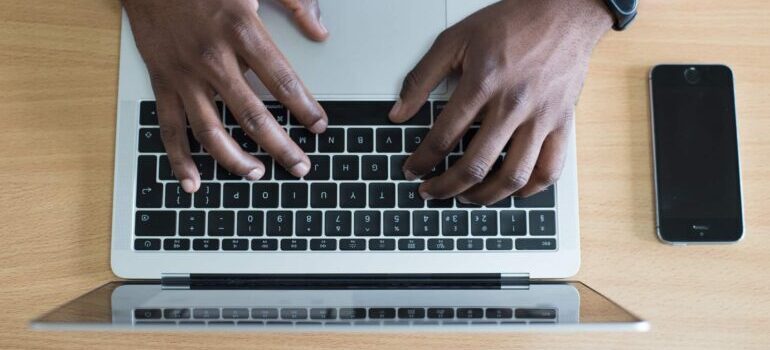 A man is typing keywords into his laptop.