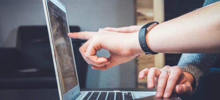 A person pointing at a laptop screen while learning to use a Google Business Profile to get more customers