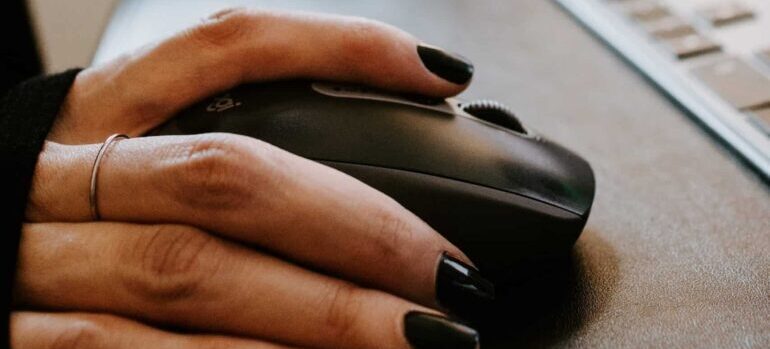 A person using a wireless computer mouse.