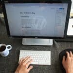 A person writing on the topic of ''how to write a blog'' after reading about why every moving company needs a blog