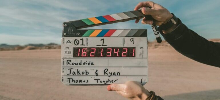 A director holding a clap so as to mark the start of shooting a video, which is also one of the types of content for better engagement