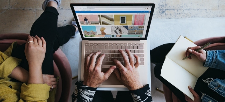 Three people sitting and using a laptop to research how to rank in Google Maps