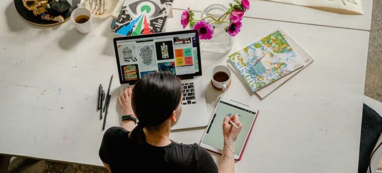 Graphic designer sitting at a desk and working on her tablet