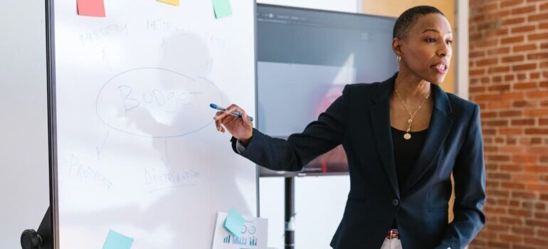 Woman pointing at a white board and explaining the difference between social media VS traditional advertising