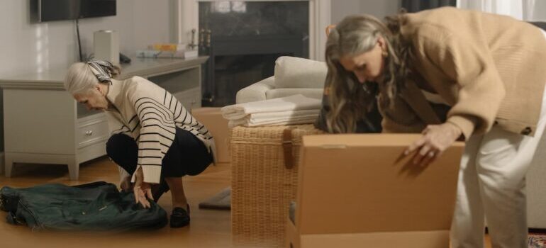 Two elderly women packing for a move