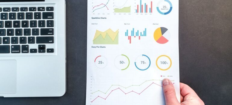 Paper with data and charts on it next to a laptop