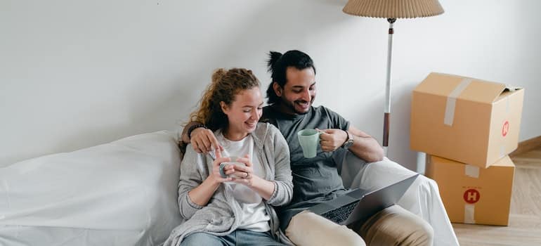 Two people looking at their laptop while packing