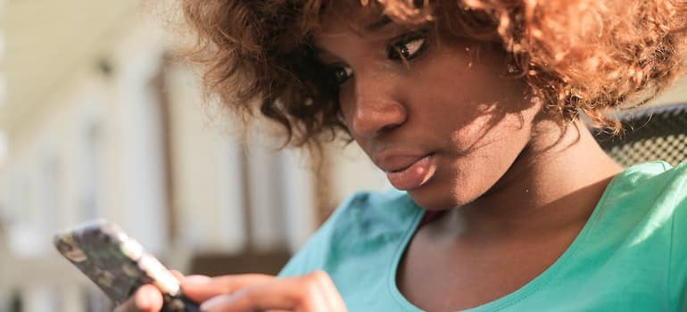 young woman looking at her phone at strategies for moving companies to target renters