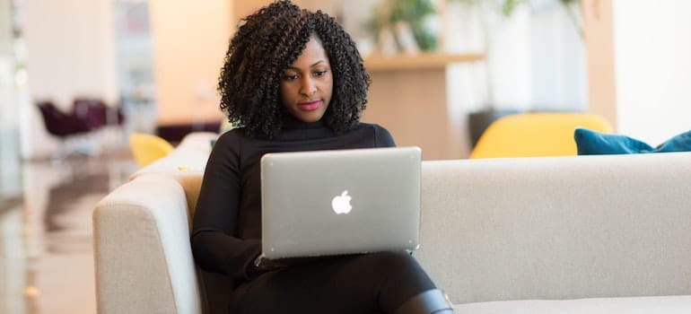 woman going through a moving company's page on a laptop