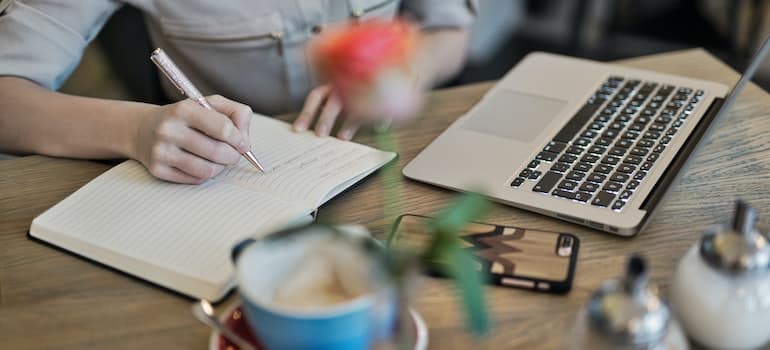 A woman in front of a laptop following digital tips for movers on a budget and creating content for her website