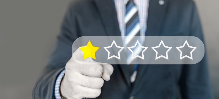 A man pointing to a one-star rating, underscoring why your moving company needs a great About Us page for reputation management.