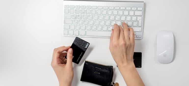 a close-up of hands holding a credit card for online purchase