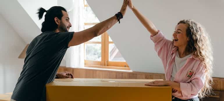 a happy couple high-fiving each other after the move