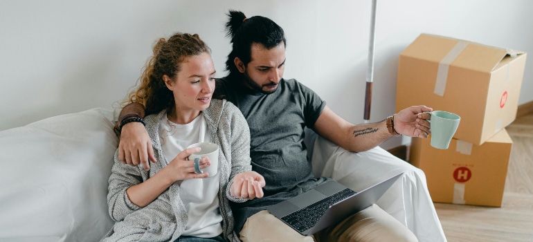 couple using a laptop while preparing for a move