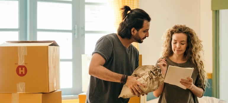Happy couple unpacking boxes in new home