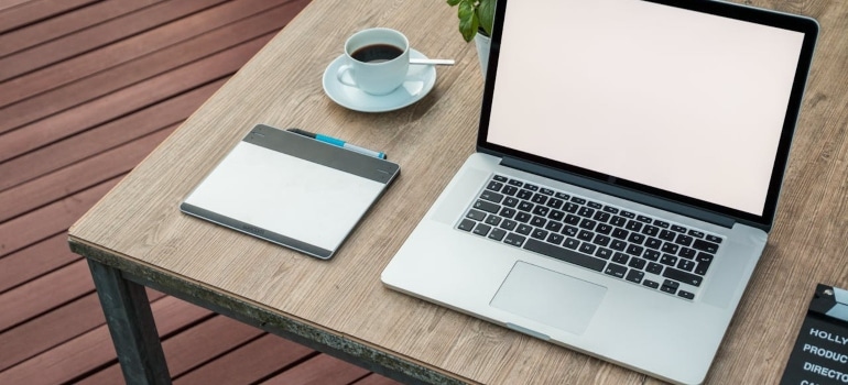 a computer and a cup of coffee on a wooden desk