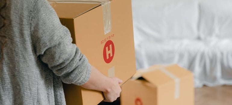 A person carrying a carton box while moving