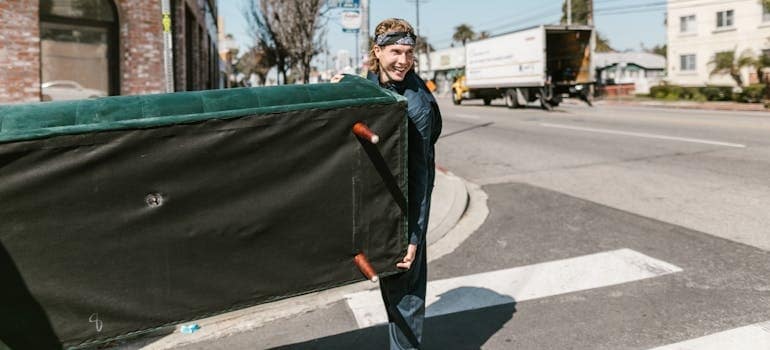 A person carrying a couch