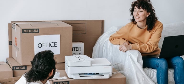 Two people searching for movers while packing