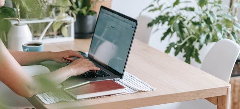 A person using a laptop and making changes in marketing strategies after learning how service area pages help movers rank locally