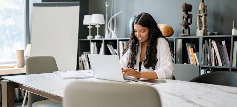 A person using a laptop and reading about ADA compliance matters for moving companies