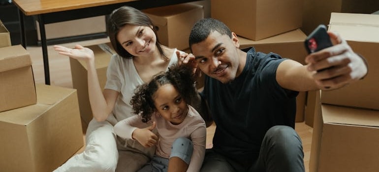A family taking a selfie while sitting between boxes