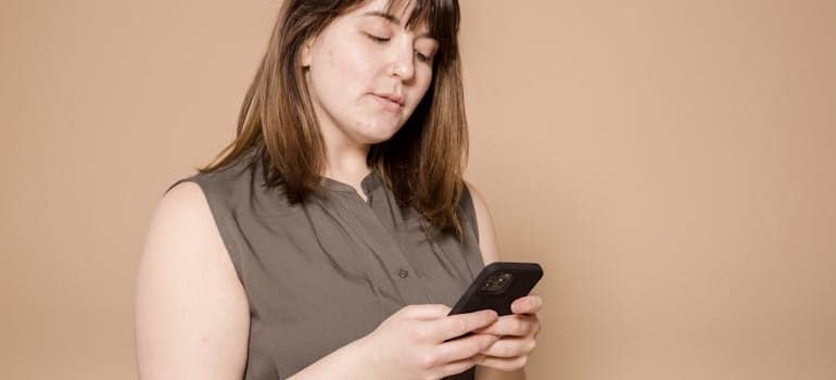 A person using their smartphone to read online reviews about a moving company