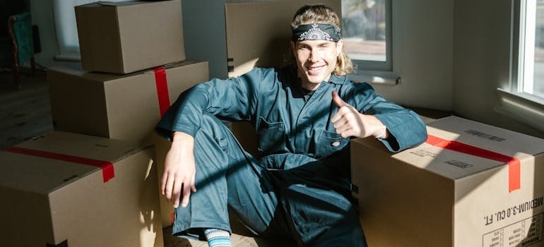 An employee of a moving company sitting among boxes