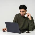 A person holding a credit card while using a laptop