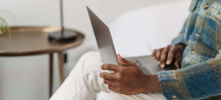 A person using a laptop to search for moving companies