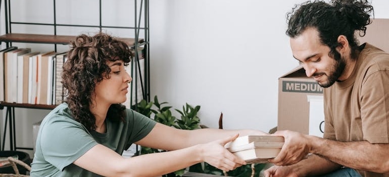 Two people packing their items and preparing for a move