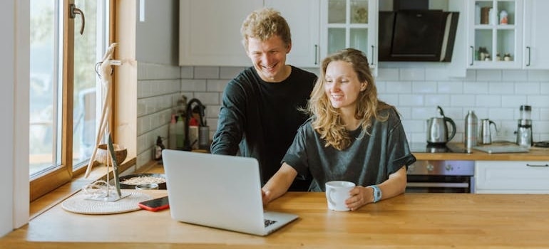 A couple using a laptop to look for moving companies in their area