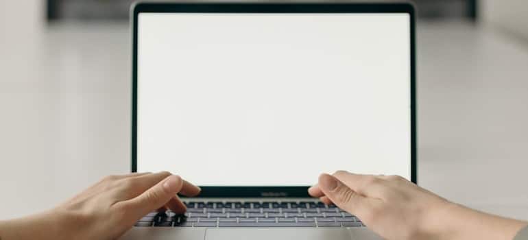 A person using a laptop and typing to search online
