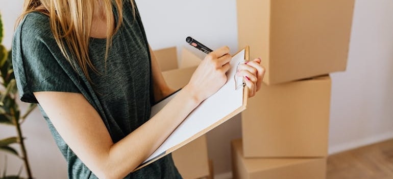 A person taking notes of their items while moving