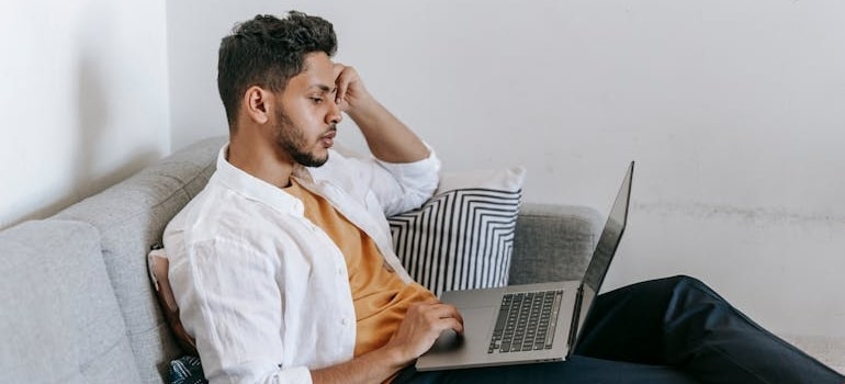 A person using a laptop to look for moving companies in spring which is the ideal time to refresh your moving company's online presence